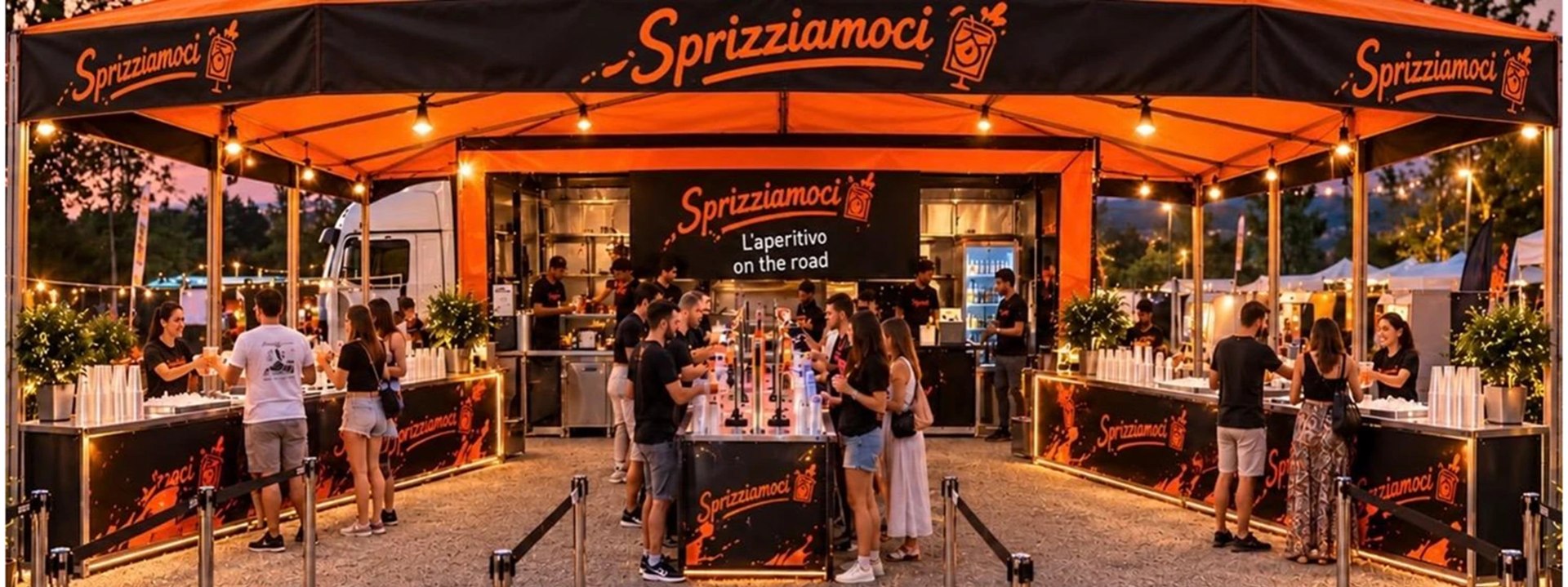 L'allestimento Sprizziamoci in funzione: gazebo nero e arancione, banconi self service e ospiti che brindano